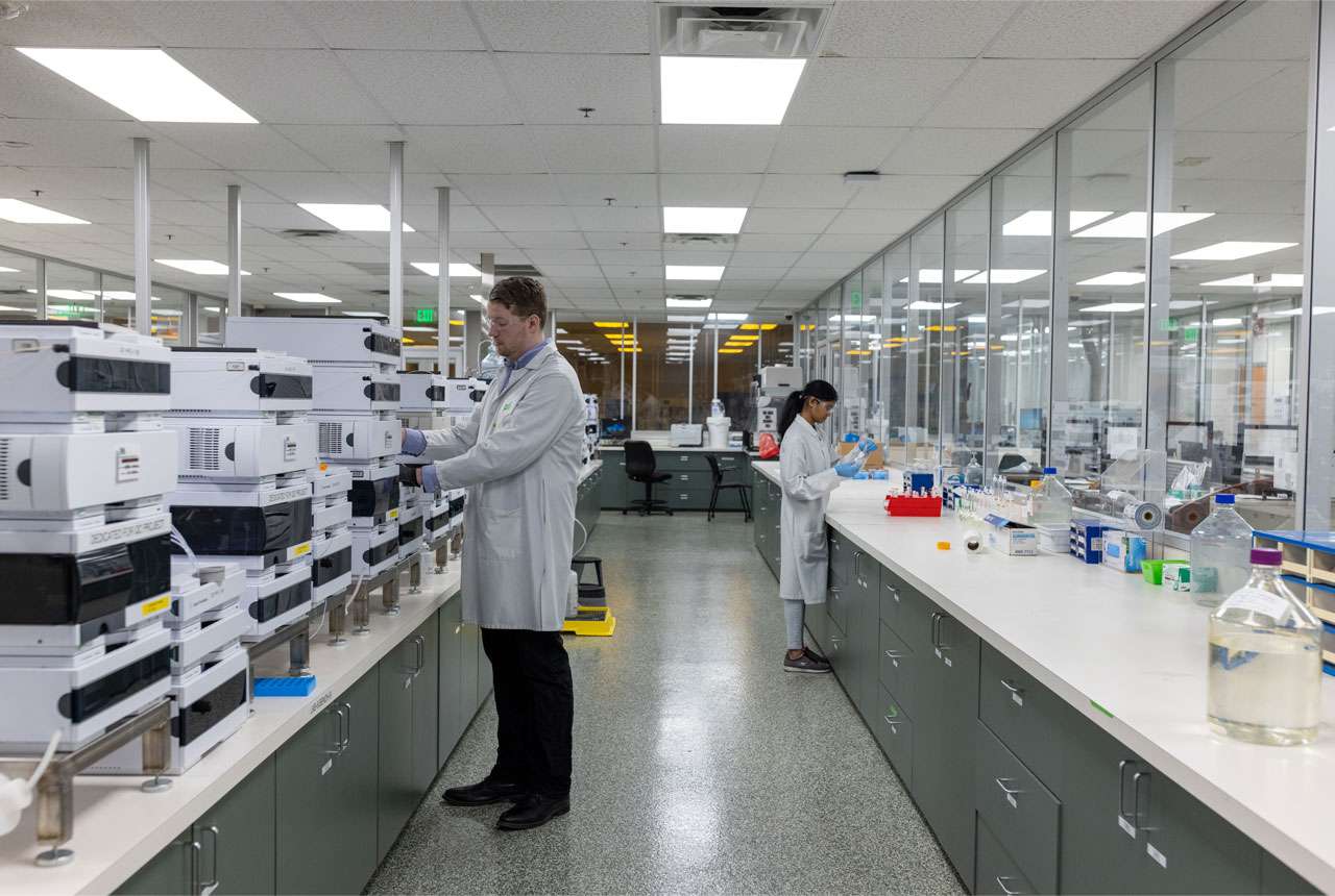 Large Pii analytical development services facility with rows of new looking instruments and equipment.