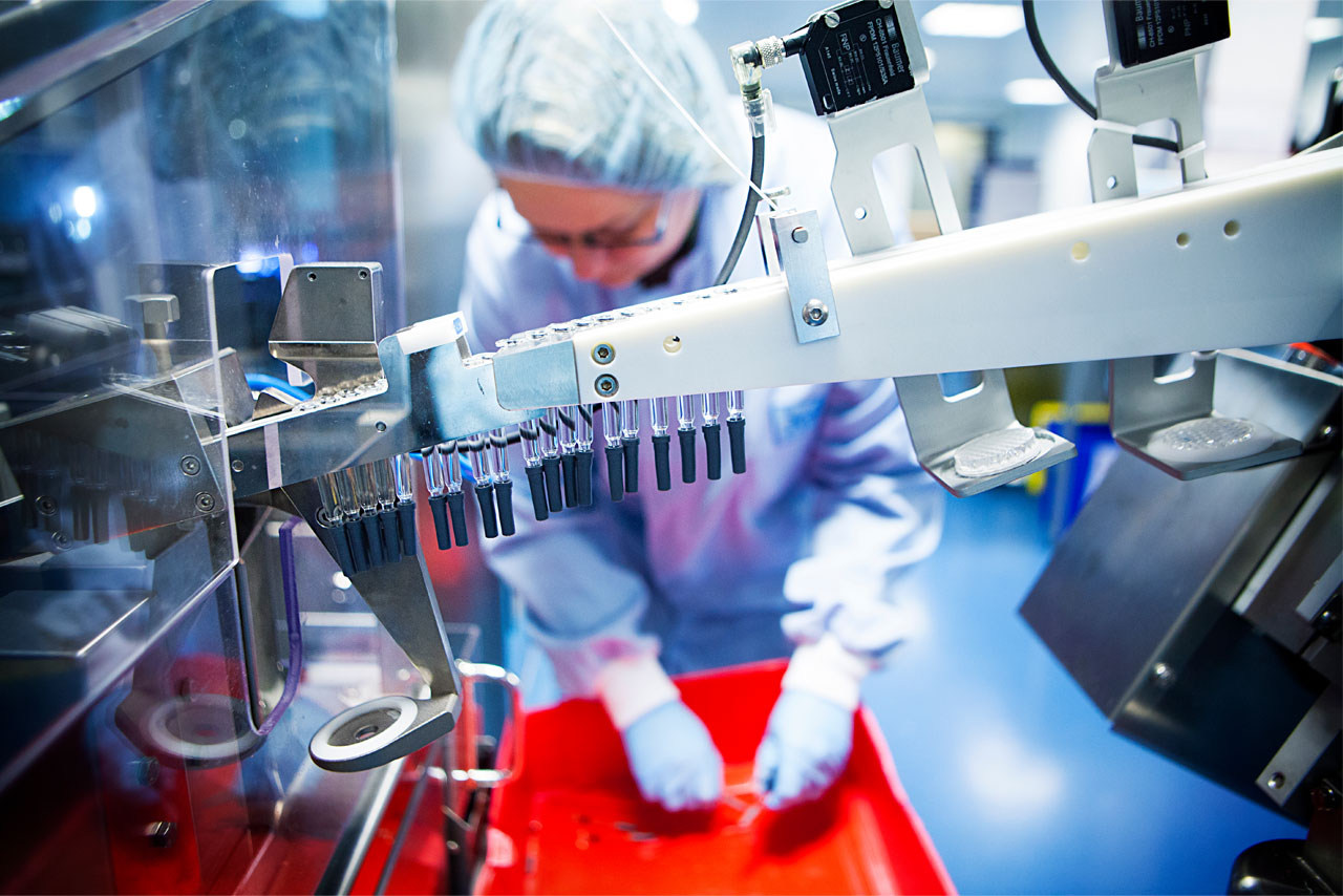 Pii scientist preparing aseptic filling line with prefilled syringes.