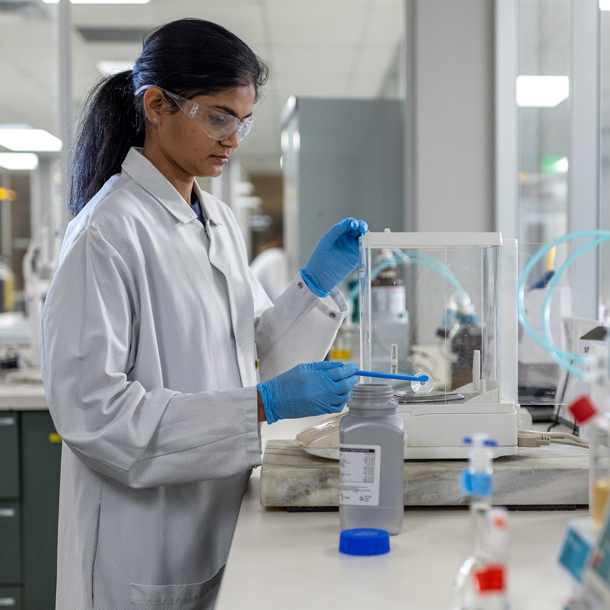 Pii scientist weighing raw materials at a weigh station.